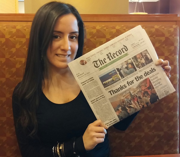 The Class of 2009 graduate holds up her front page story, which recently ran in The Record.