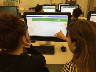 Ms. Annitti helps a student follow a tutorial on how to program.