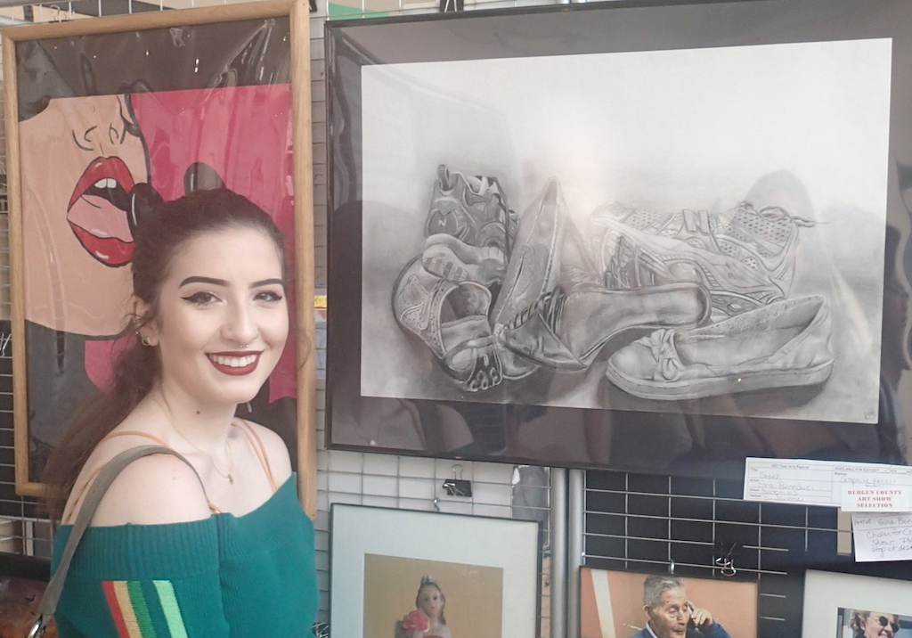 Senior Gina Beneduci proudly stands next to her award-winning artwork.