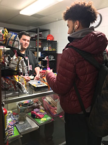 Junior Nicola Mitarotonda purchases a snack from Bectons school store while Senior David Brizzolara donates his time to help run it.