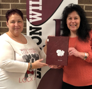 Ms. Klamerus and Mrs. Ferris hold up the 1989 Becton Tea Leaf, which is the year that they began their career at the school.