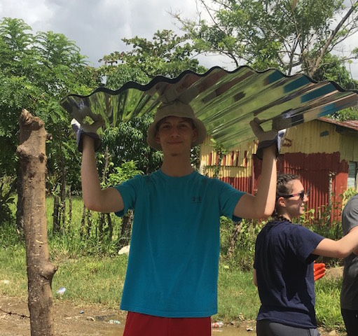 Senior Joseph Knoll helps move roofing materials.