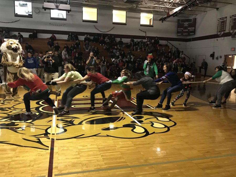 The female teacher & staff compete with the seniors in a tug-of-war.
